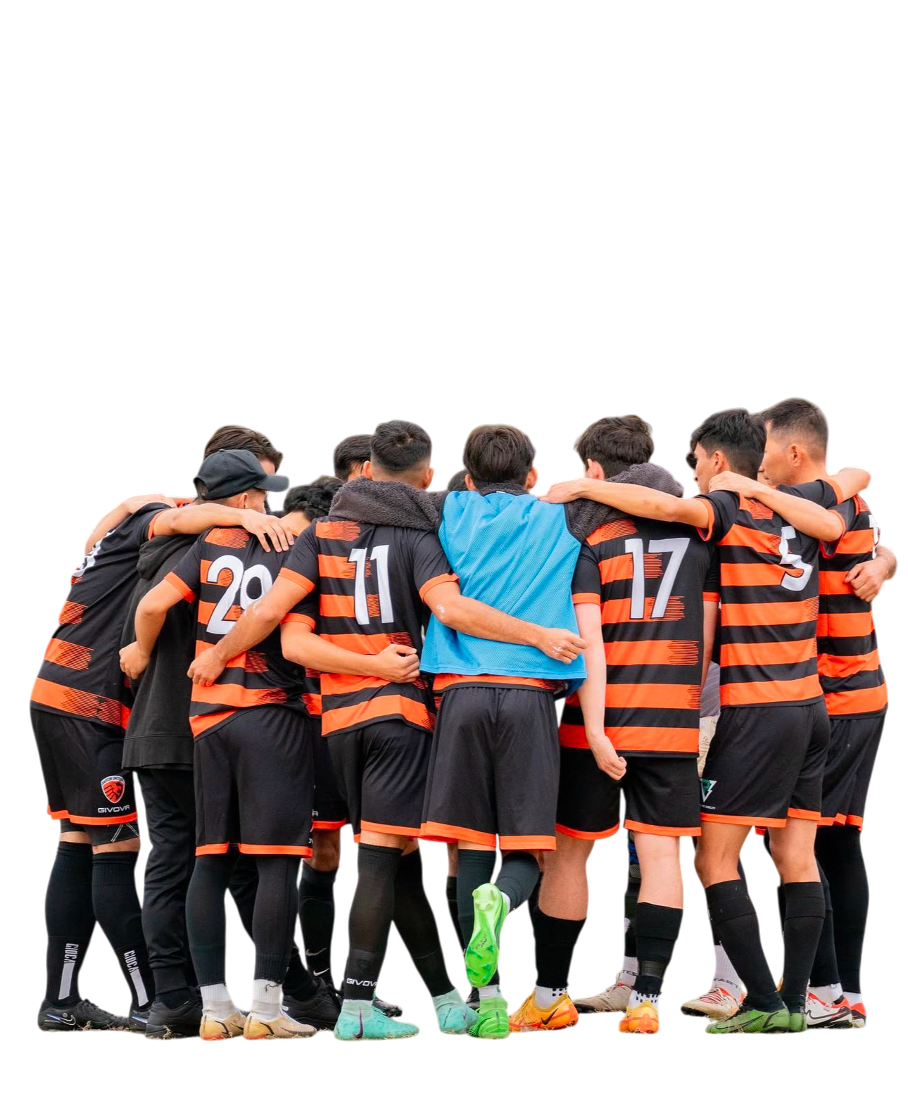 A group of soccer players in black and orange uniforms huddled together with arms around each other, facing inward on a field.