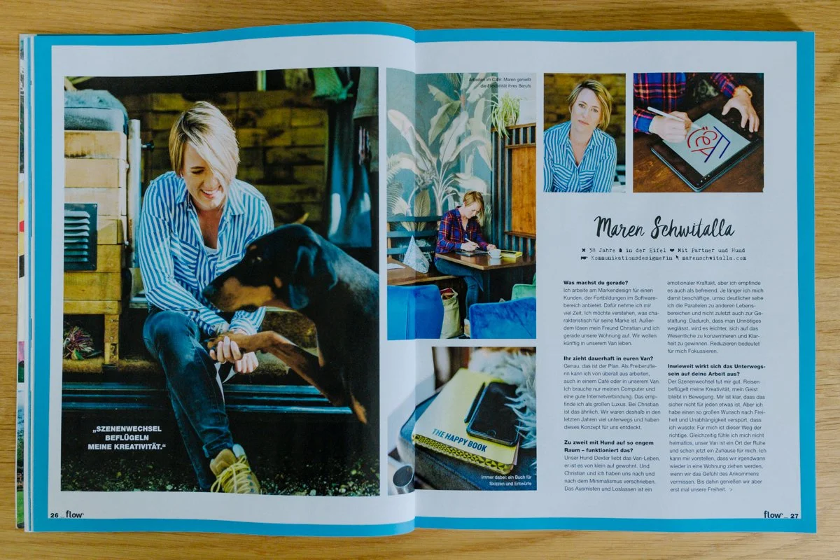 Ein Magazin mit Fotos einer Frau, die mit einem Hund spielt und in einem Raum sitzt, sowie einem Buch und Notizen auf einem Tisch.