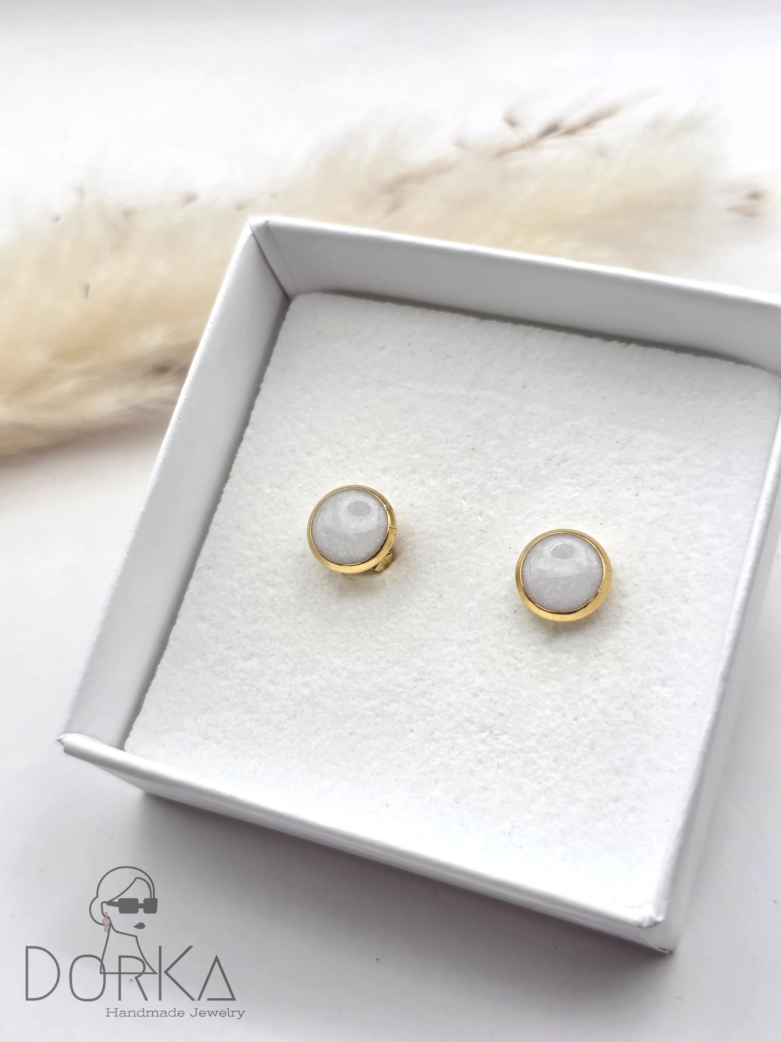 Goldene Ohrringe mit weißen Steinen in einer weißen Schmuckschachtel, DORKA Handmade Jewelry