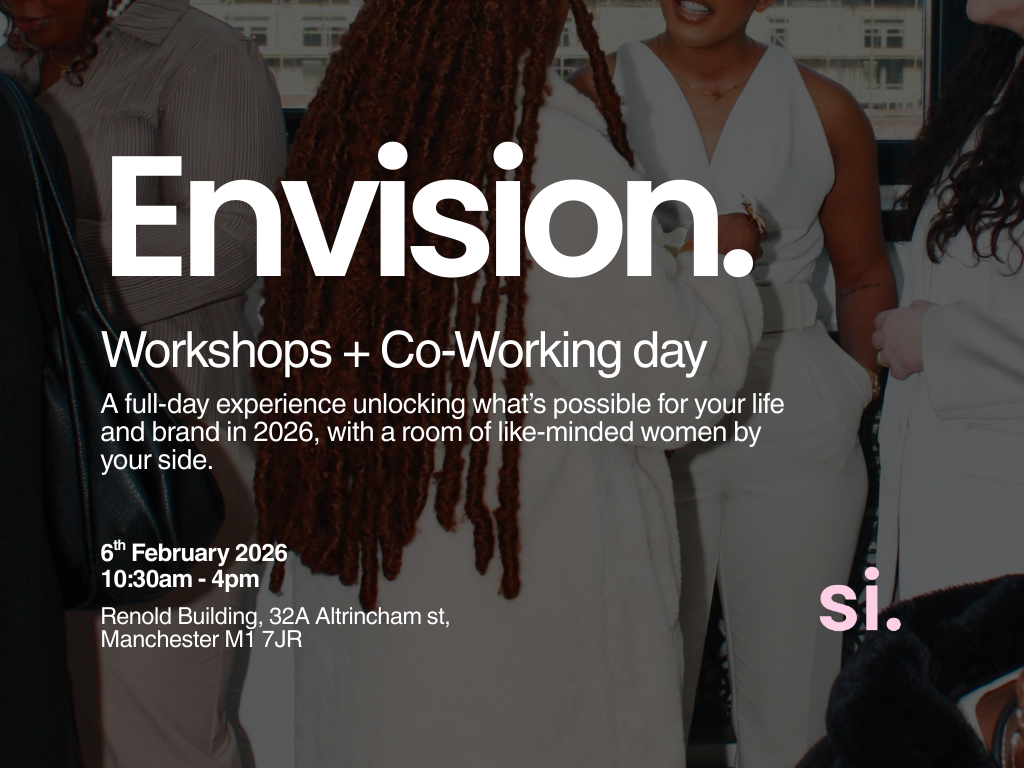 A group of women in a professional setting, standing and talking, with some women wearing white outfits and one woman with long braids, indoors with windows in the background.