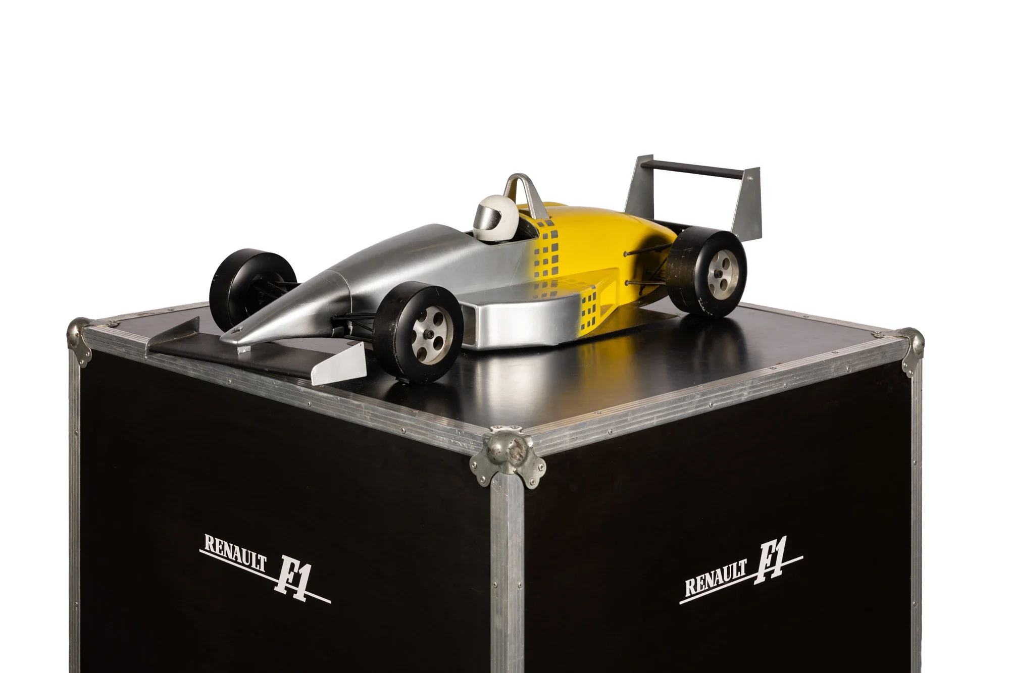 Une maquette de voiture de course de formule 1 Renault, de couleur jaune et argent, placée sur une caisse noire avec des inscriptions Renault F1.