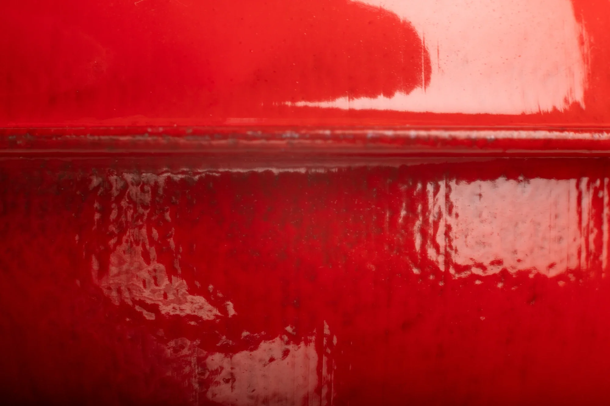 Texture en rouge avec des reflets brillants et des lignes horizontales.