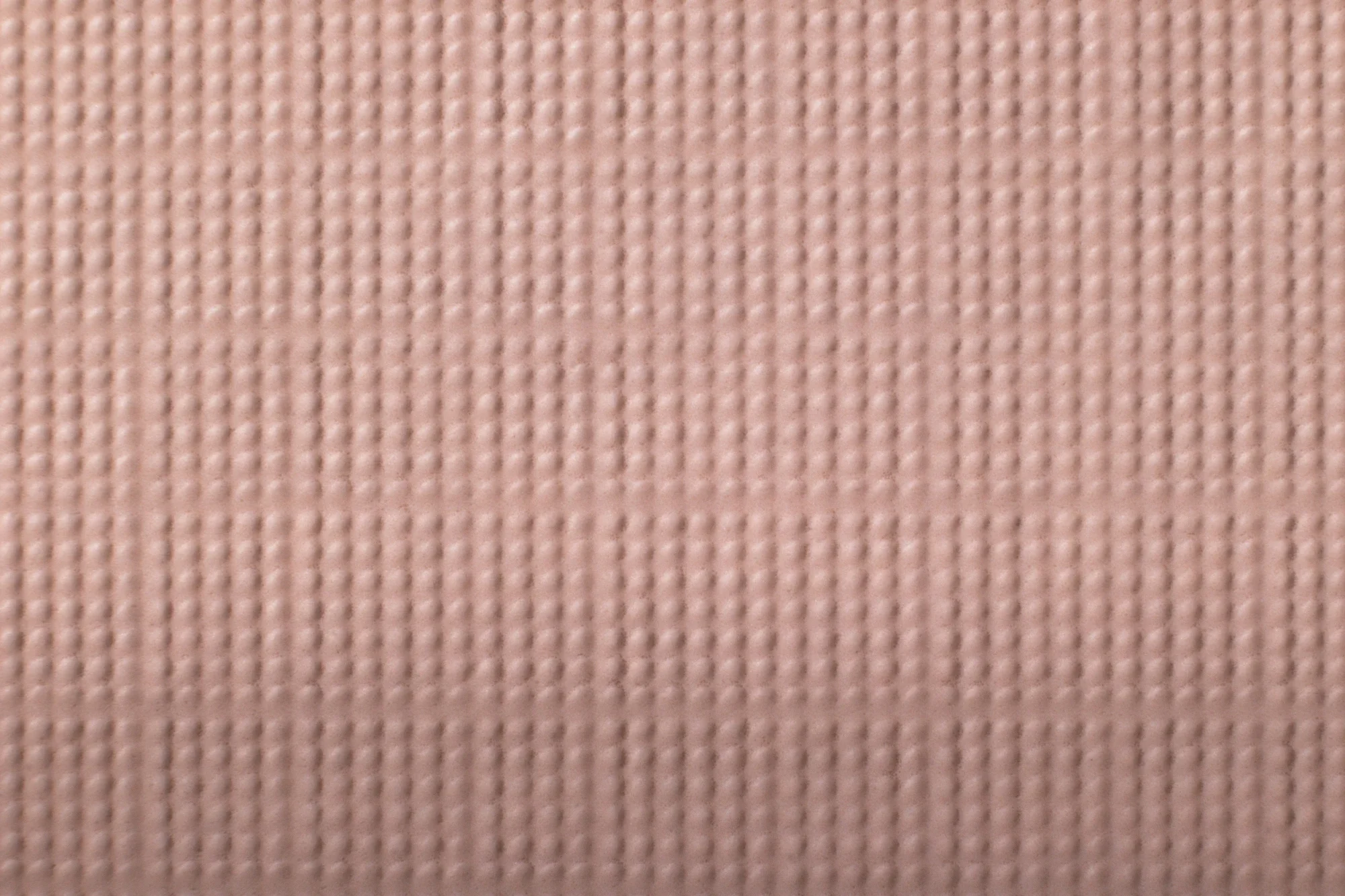 Texture en tissu rose clair avec un motif en damier.