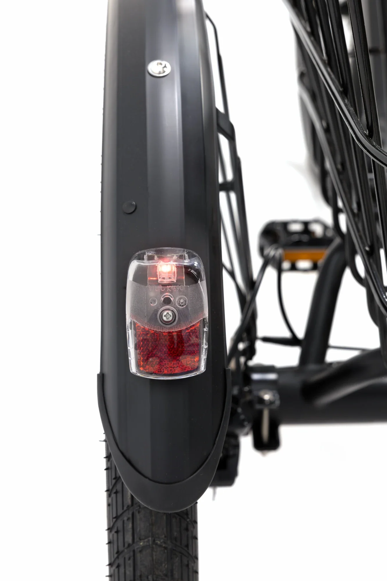 Photo d'une roue de vélo avec un feu arrière rouge allumé, vue de l'arrière, avec une chambre à air noire et un système d'éclairage intégré.