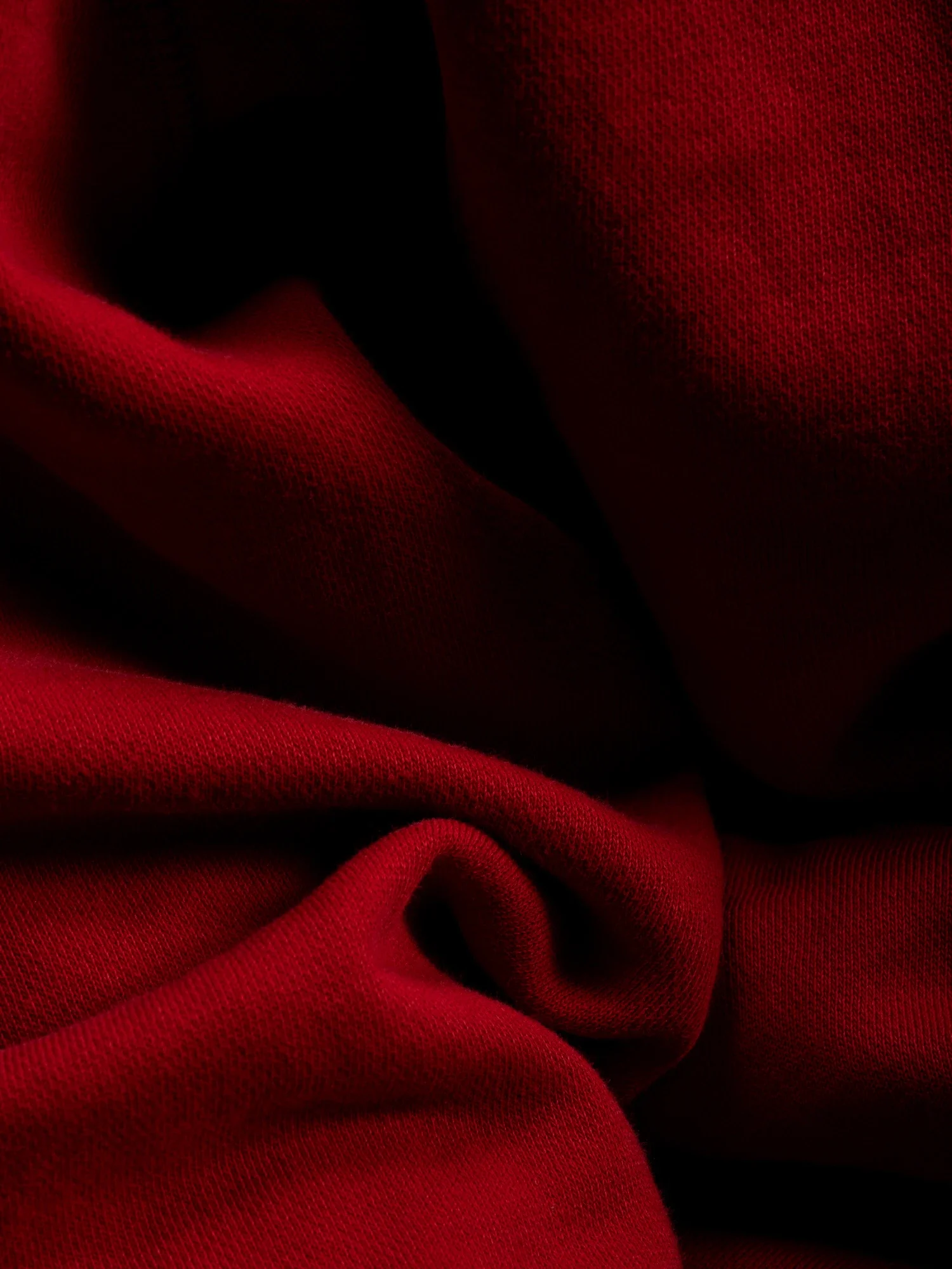 Tissu rouge en tissu épais avec des plis et des textures visibles.
