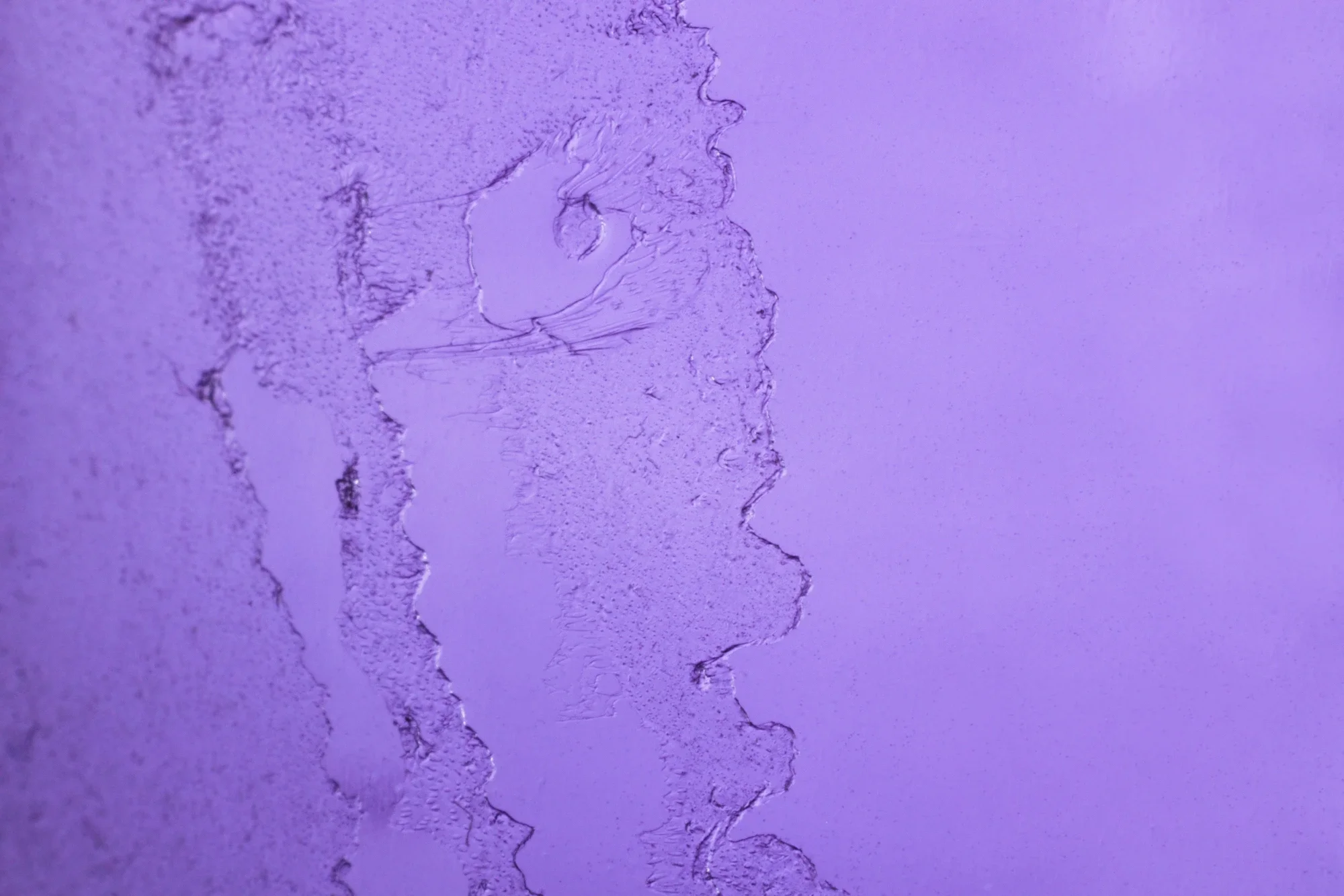 Une surface violette avec des fissures et déchirures dans la matière, créant un motif irrégulier.