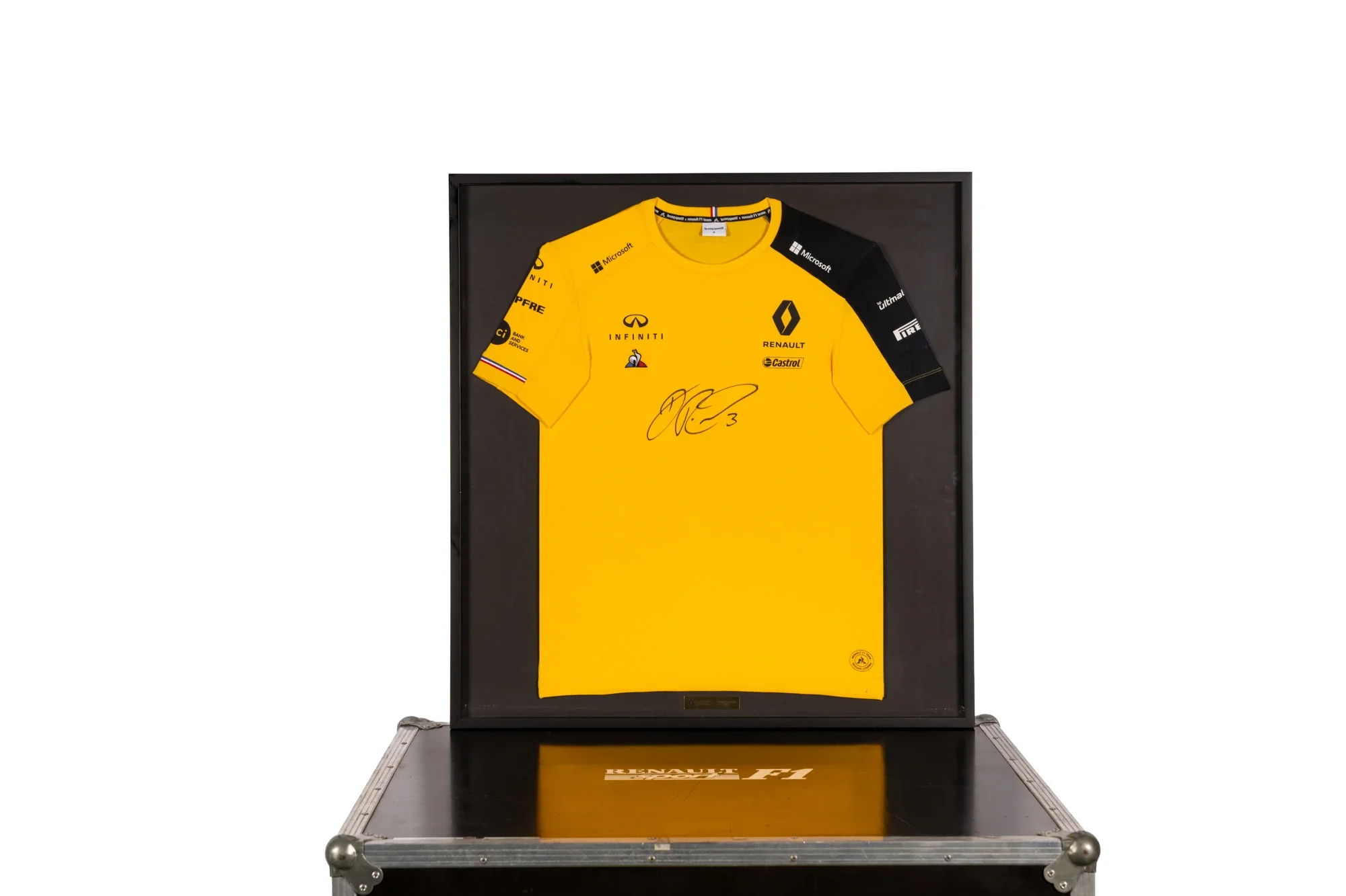 Vitrine contenant un maillot de course jaune de Renault Sport F1, avec des signatures et logos de sponsors, encadré.