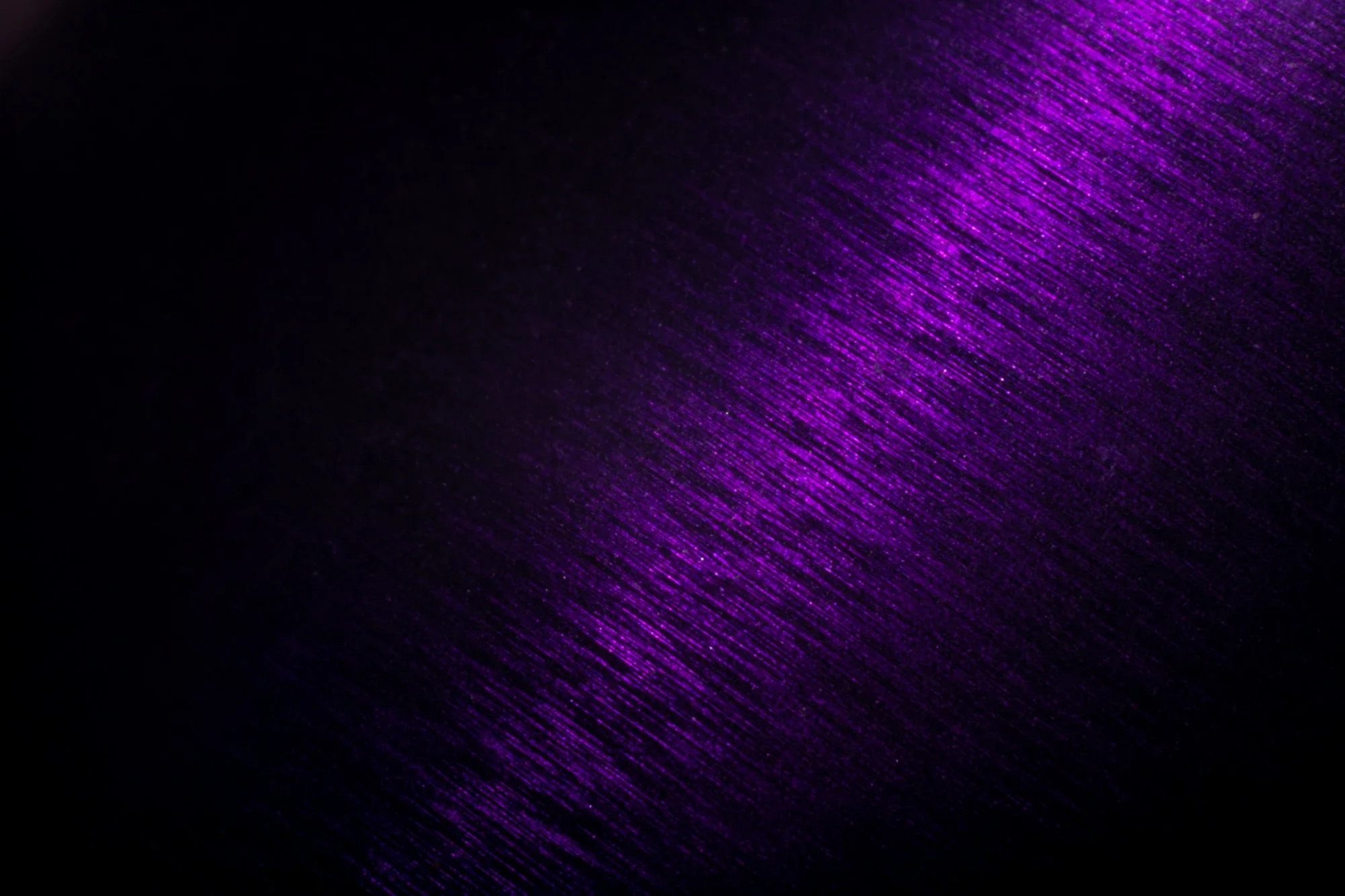 Un fond noir avec des lignes diagonales violettes brillantes créant un effet lumineux abstrait.