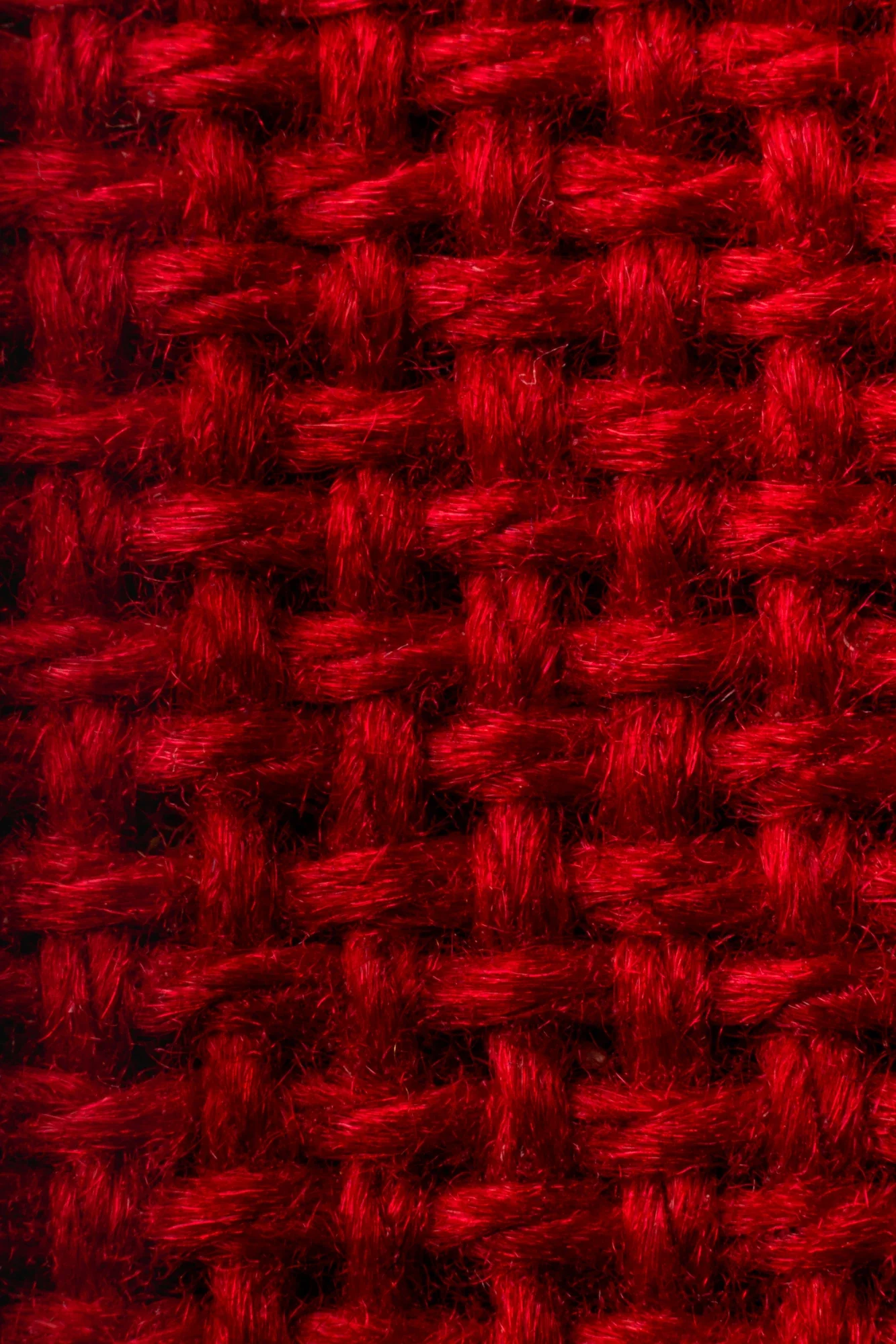 Gros plan d'un tissu en laine rouge avec un motif tissé en damier.