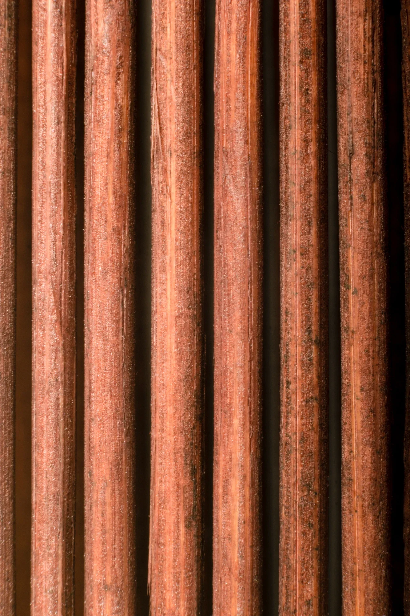 Gros plan de barres de fer rouillées couleur rouge-brique.