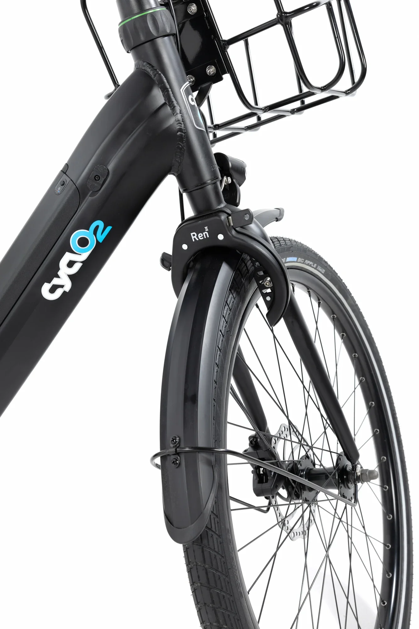 Vue partielle d'un vélo électrique noir avec un panier à l'avant, un pédalier, une roue avec un pneu Big Apple, et le cadre avec un logo Envo. Le vélo a une fourche avant suspendue et un garde-bout.