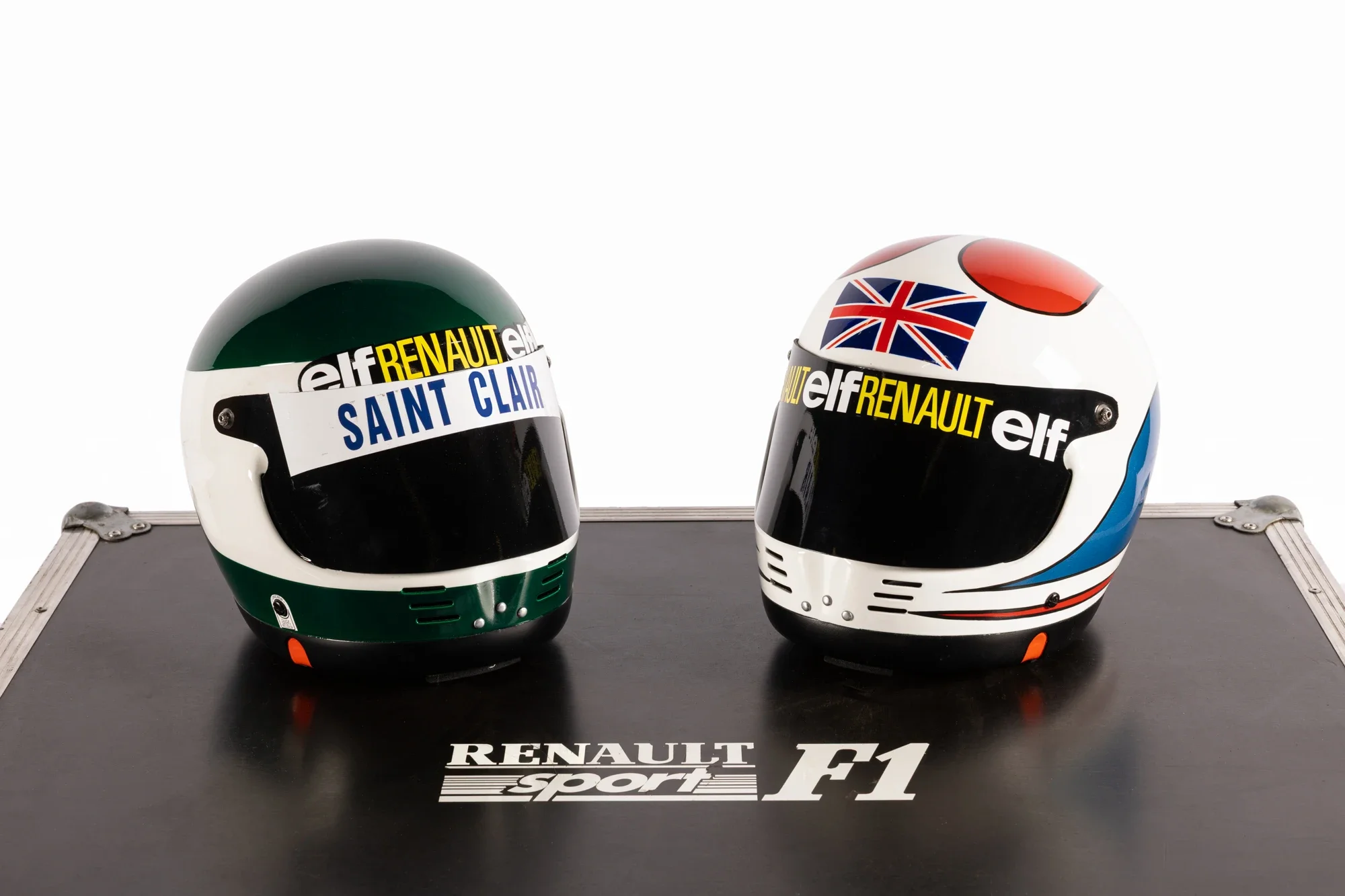 Casque de course de Formule 1 avec logos Renault, Elf, Saint Clair, un drapeau britannique, positionné sur une table avec logo Renault Sport F1.