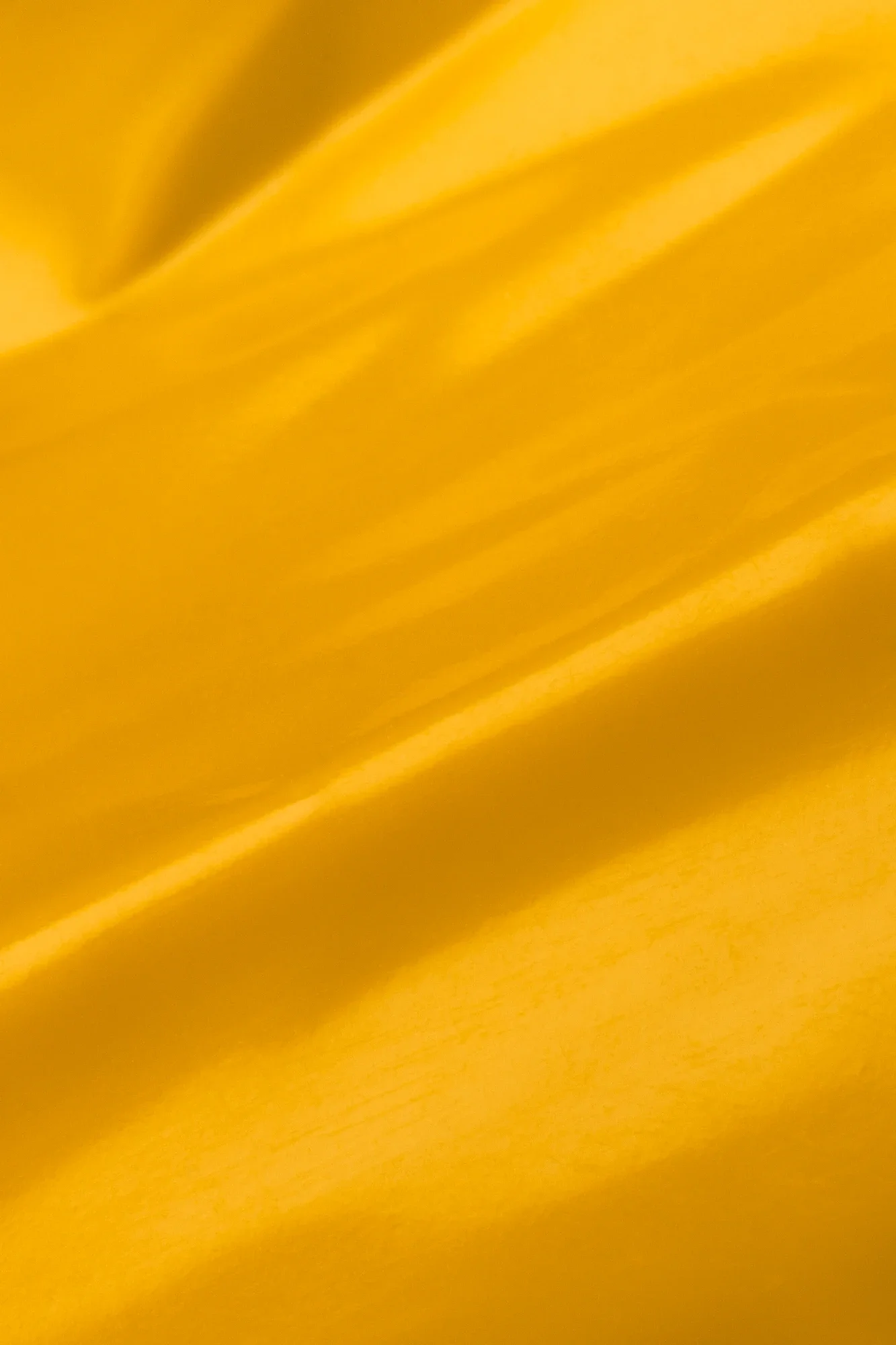 Une surface jaune vibrante avec des rayures diagonales, probablement une feuille ou un tissu
