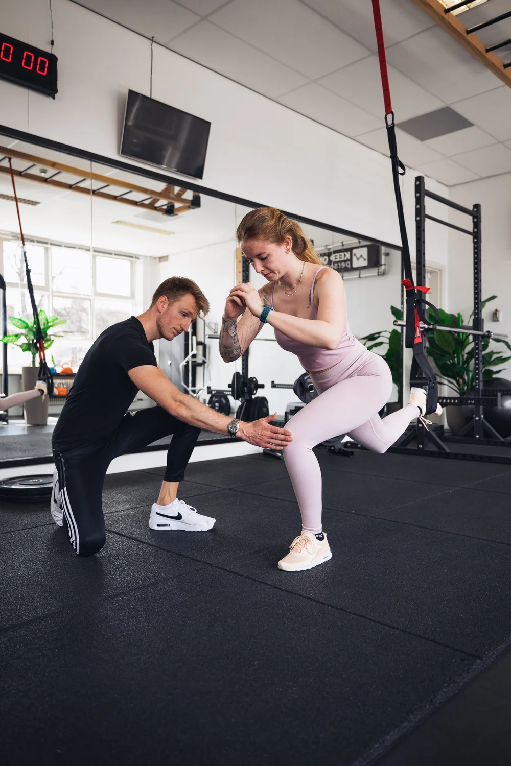 Personal trainer begeleidt een sporter bij een oefening in Haarlem