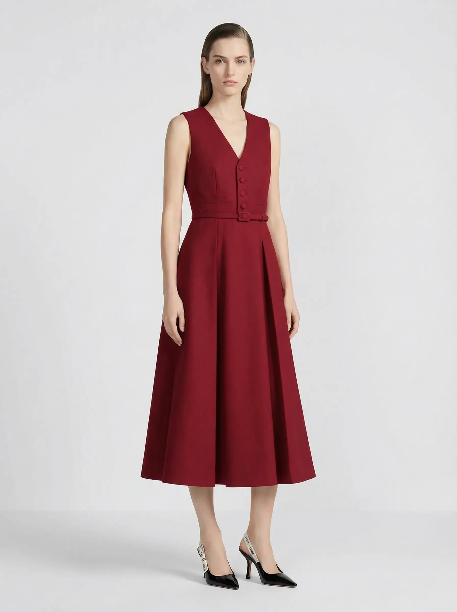 Donna con abito rosso senza maniche e cintura, sfondo bianco