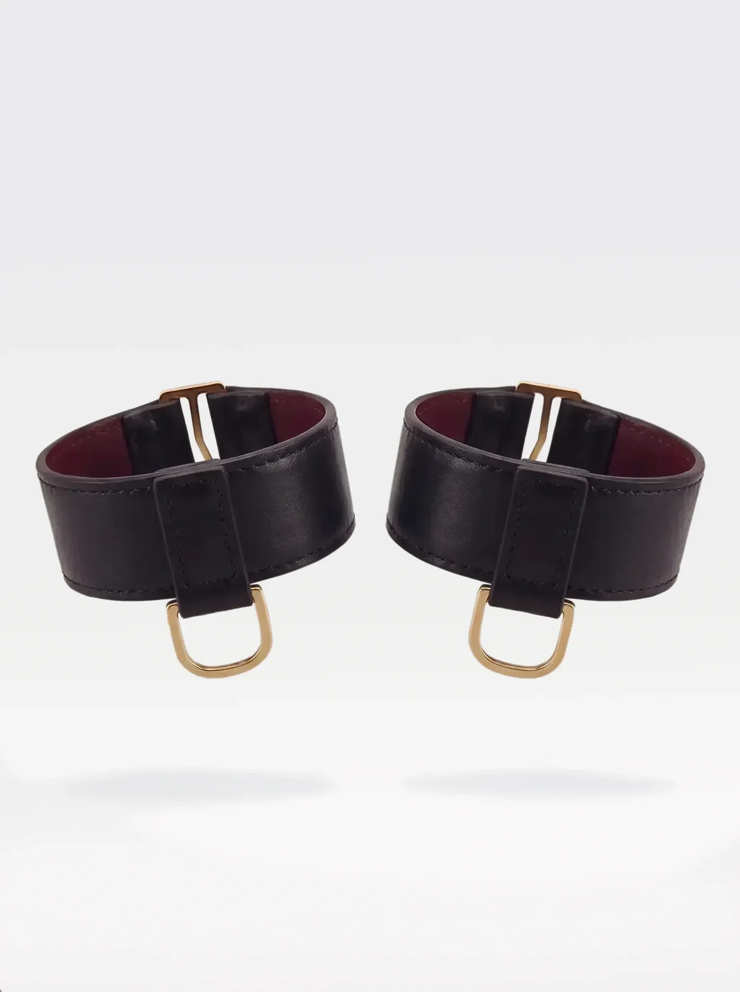 Bracciali da polso Sainte Sve in nappa nera con anello a D dorato, coppia, still life realizzato con AI