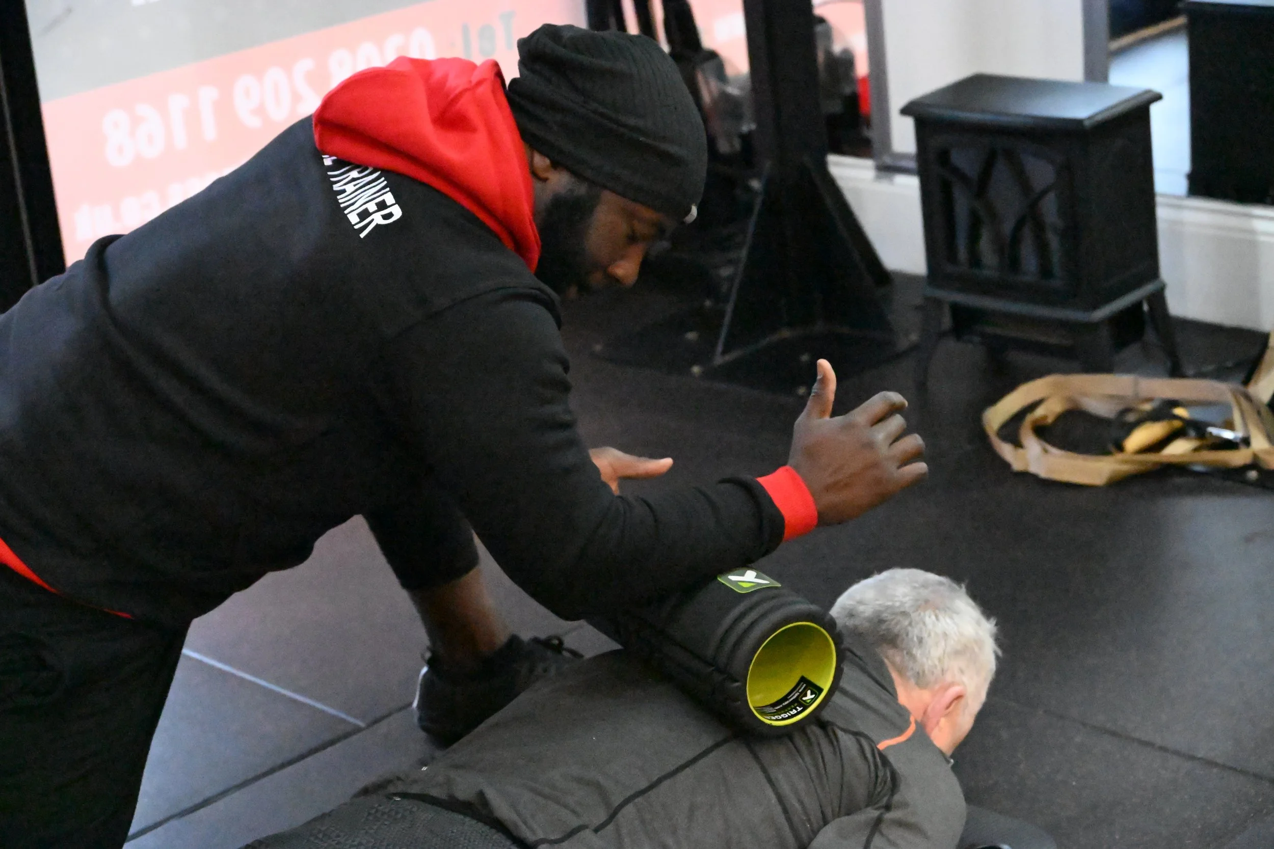 TrainRite founder, Emmanuel, using a foam roller with a client.
