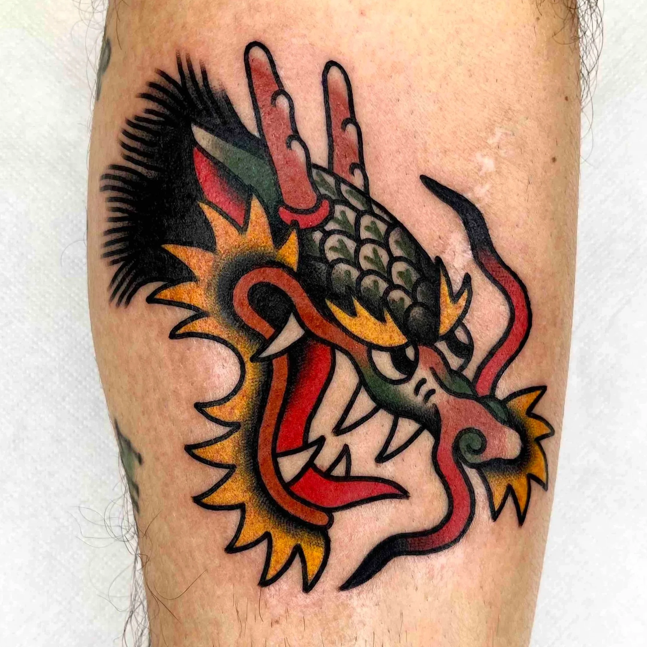 Bold traditional dragon head tattoo, handcrafted by Abra Tattoo Artist Berlin