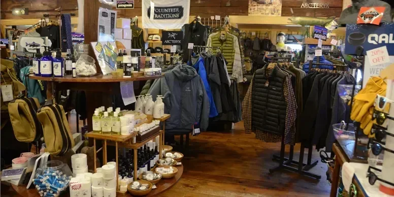 Indoor mountain gear or outdoor apparel store with jackets, hats, and accessories on display.