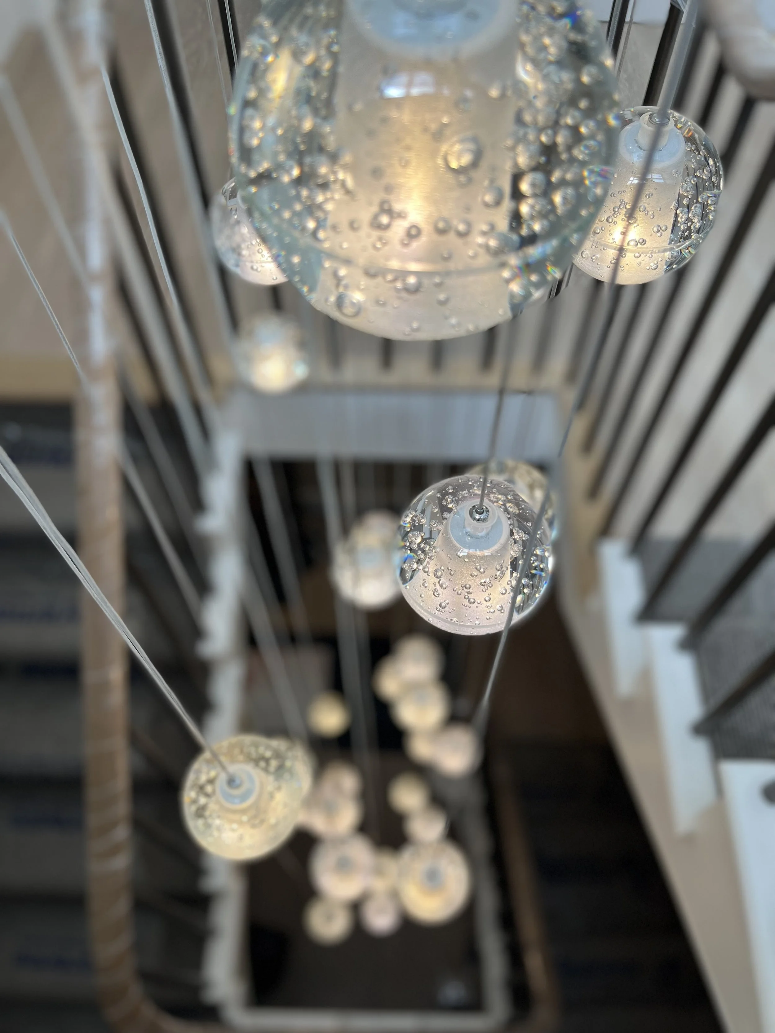 Close-up view of a modern chandelier with glass bubbles containing bubbles, hanging from the ceiling.