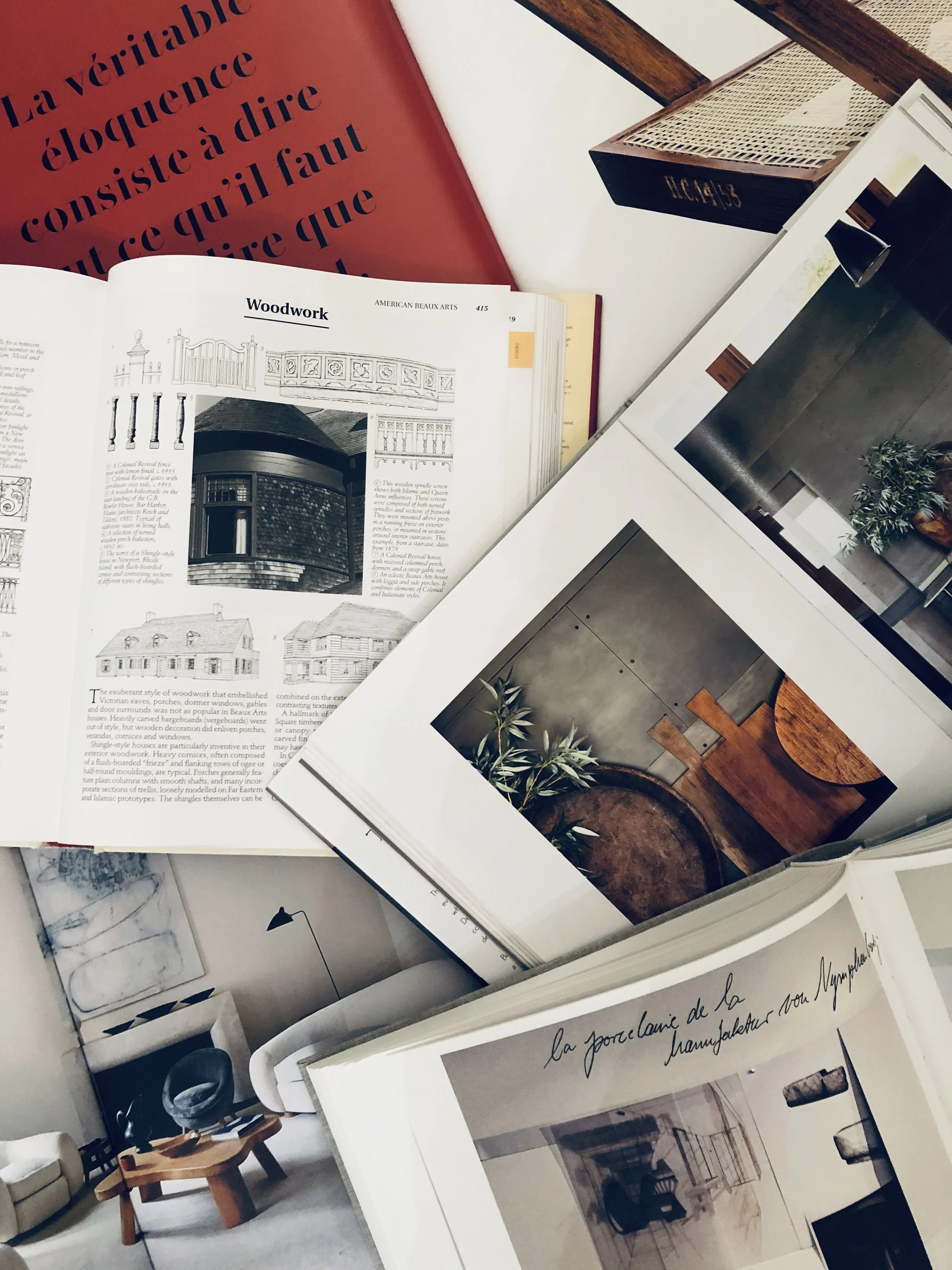 Open design books and magazines with interior design and woodwork content on a table.