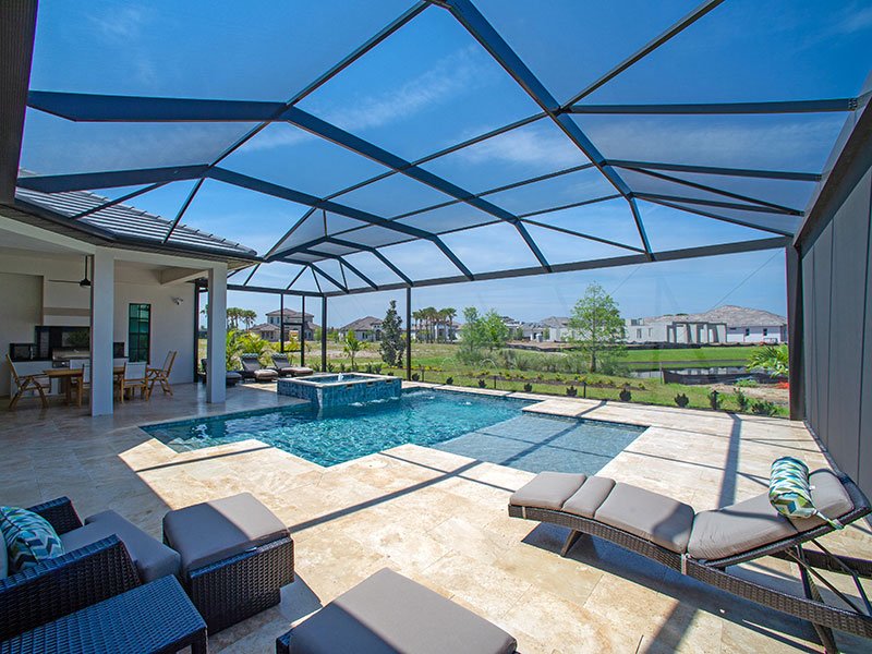 A screened backyard patio with a swimming pool, water feature, lounge chairs, and outdoor seating under a blue sky.