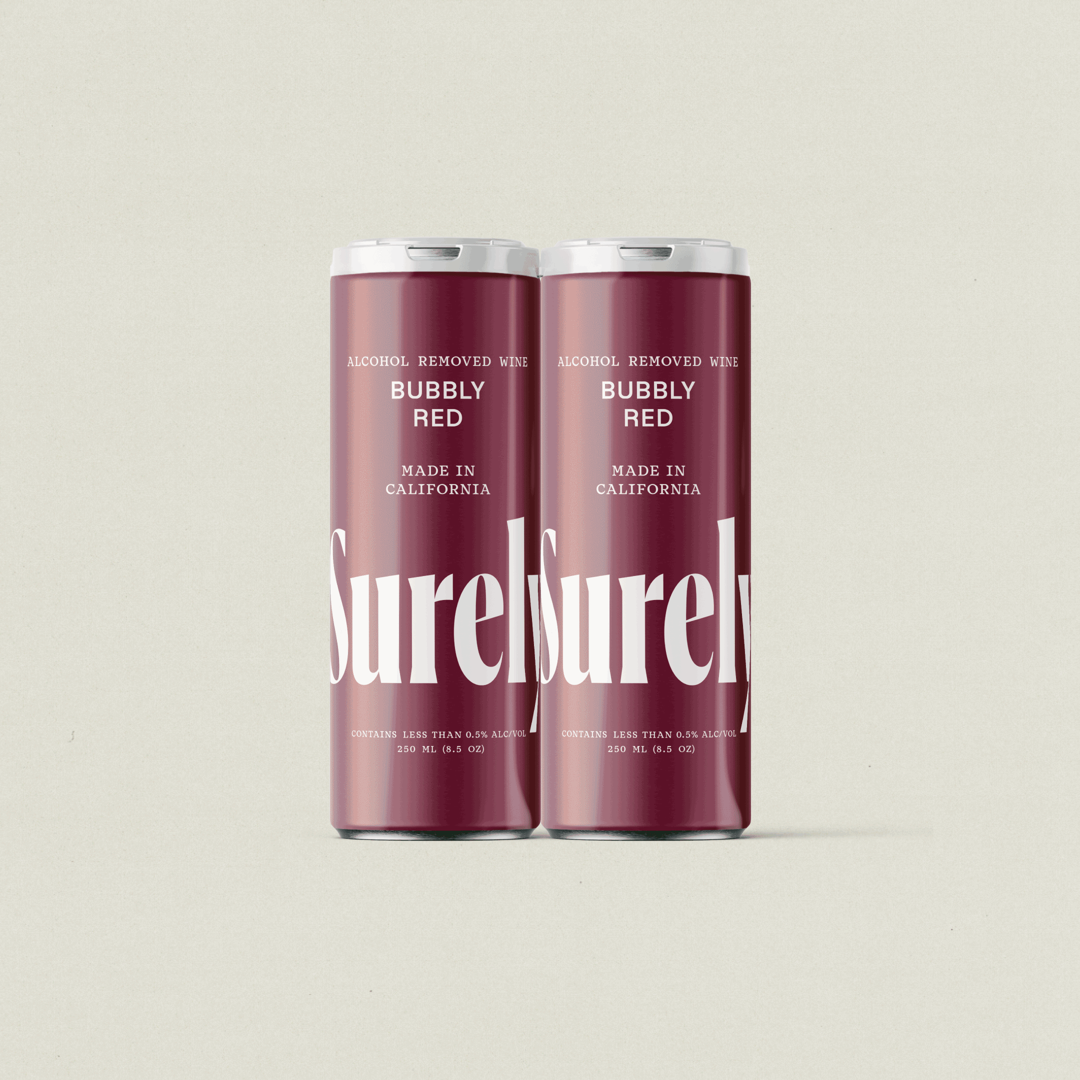 Two cans of Surreel Bubbly Red wine with a maroon label, standing side by side against a plain background.
