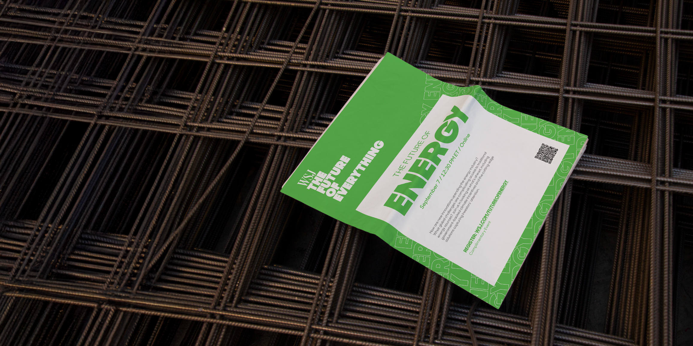 A green and white flyer for a future event titled 'The Future of Everything' with date and registration details, lying on a construction rebar grid.
