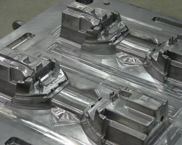 Close-up of a metal mold or die used for manufacturing, with intricate and polished surfaces likely for shaping metal parts.