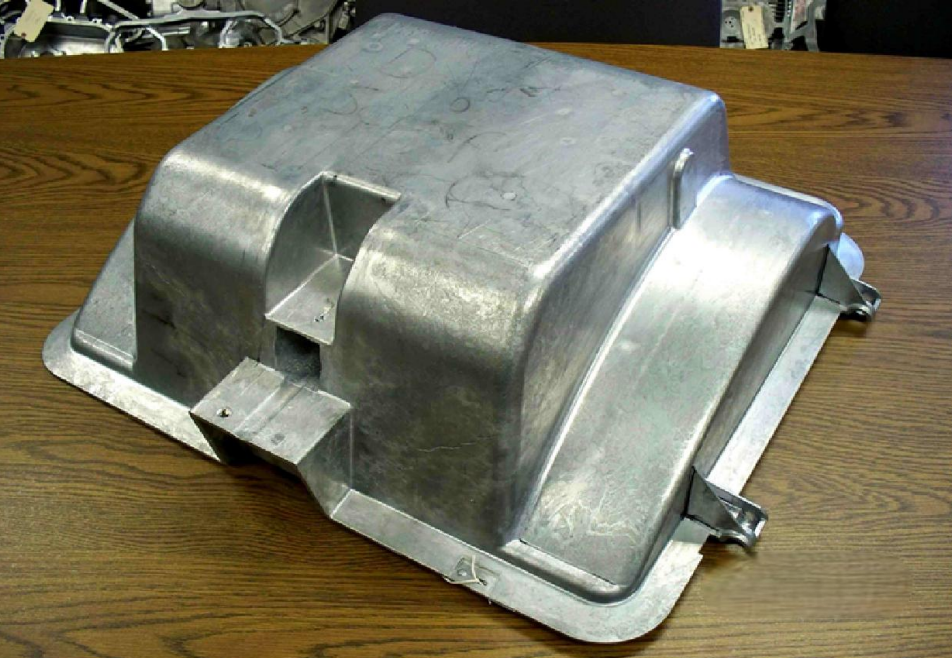 Metal automotive part or component on a wooden table.