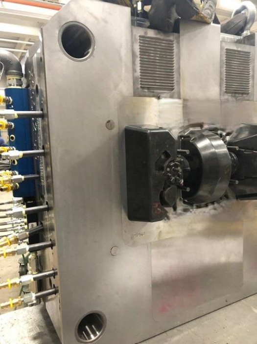 Industrial machine with metal components and multiple pipes or tubes on the left side.