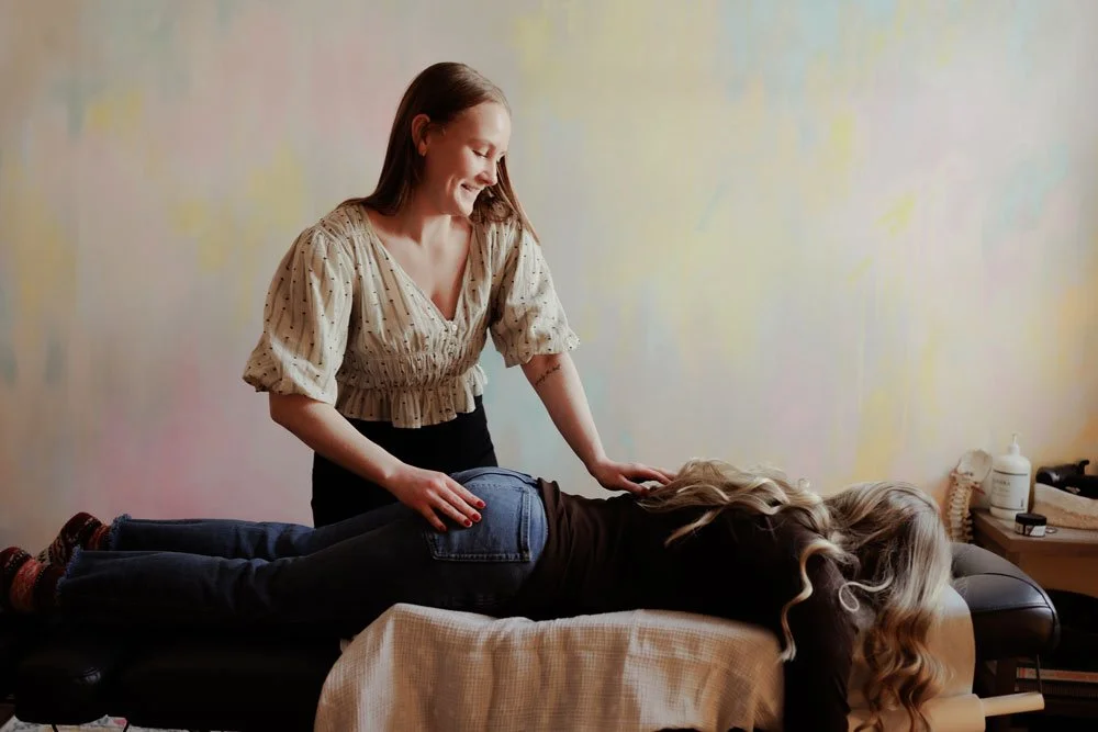 A woman receiving a massage from a massage therapist in a wellness clinic.