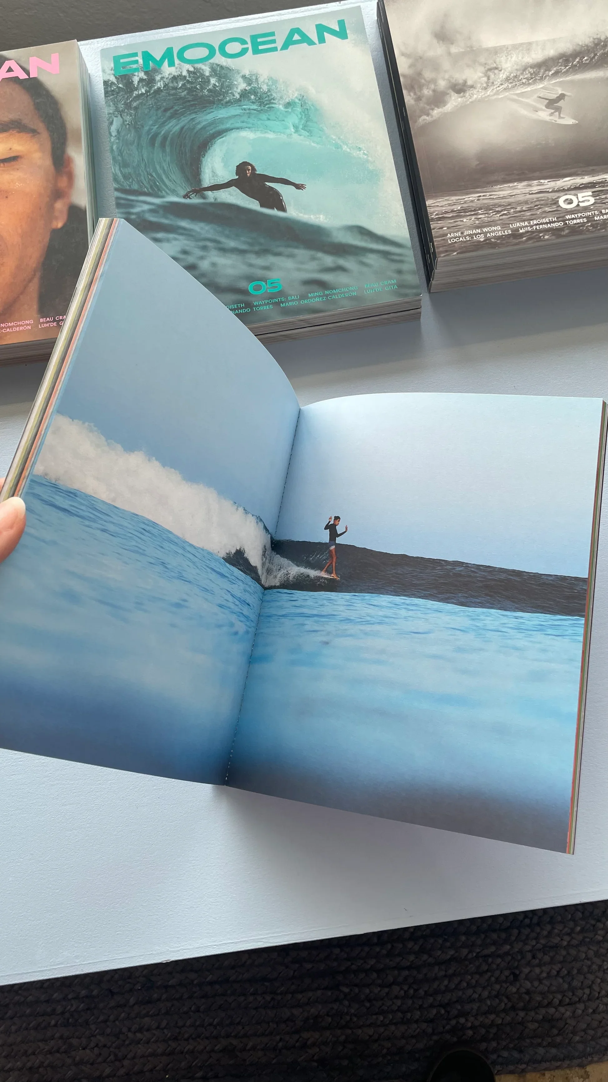 Open magazine featuring a photograph of a surfer riding a clean wave, referencing surf storytelling and lived experience.