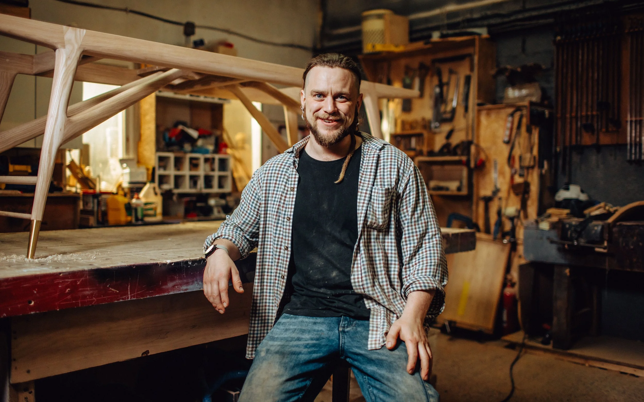 josh of josh hill furniture, sat in his workshop, in front of dressing table legs he is working on