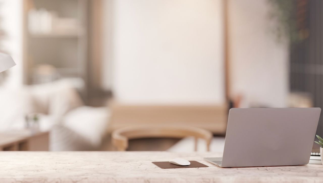 A laptop on a tidy marble desk in a calm London home office, ready for organising paperwork