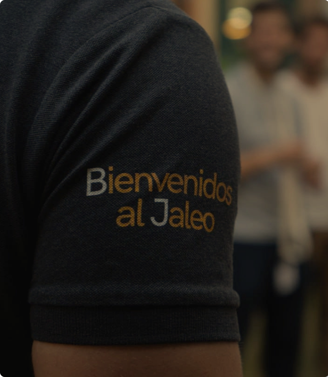 Personas en un evento de participación ciudadana con un uniforme de Jalea Demente que dice "Bienvenidos al Jaleo".