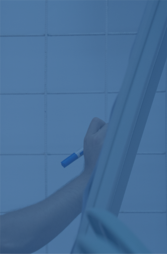 Persona escribiendo en una pizarra blanca con un marcador azul, vista desde abajo.