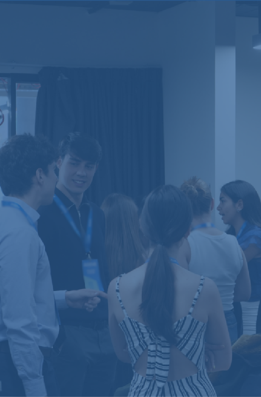 Grupo de personas en una conferencia o evento social, algunas con gafetes de identificación.