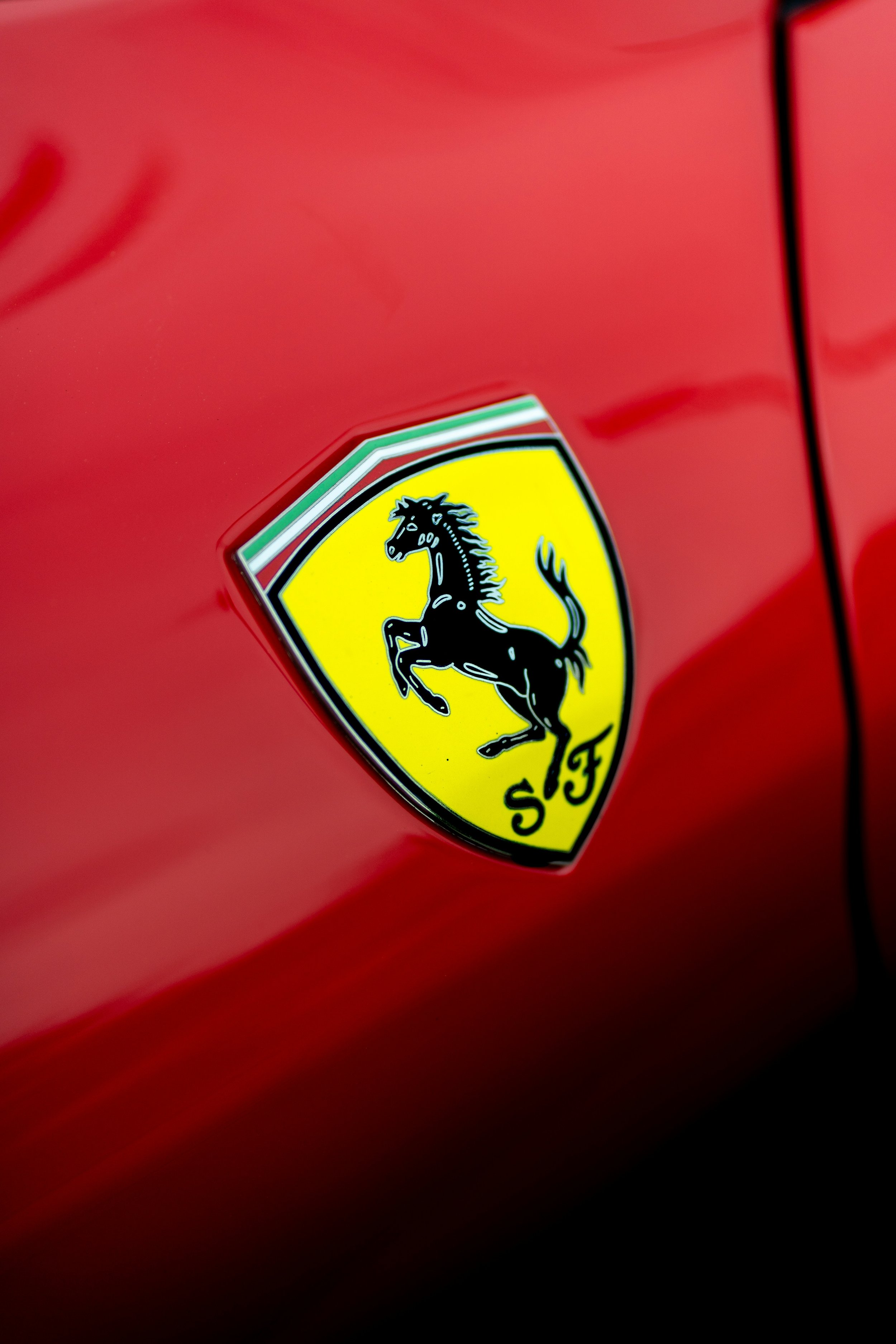 Close-up of a Ferrari emblem on a red car.