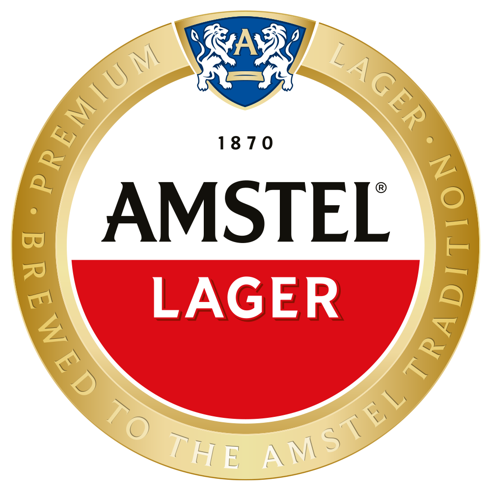 The label of Amstel Lager beer. The logo features a gold circular border with the words "Premium Lager. Brewed to the Amstel Tradition". A blue shield with two white lions and the letter "A" is at the top. The center has the text "1870 AMSTEL LAGER" with a red background behind "LAGER".
