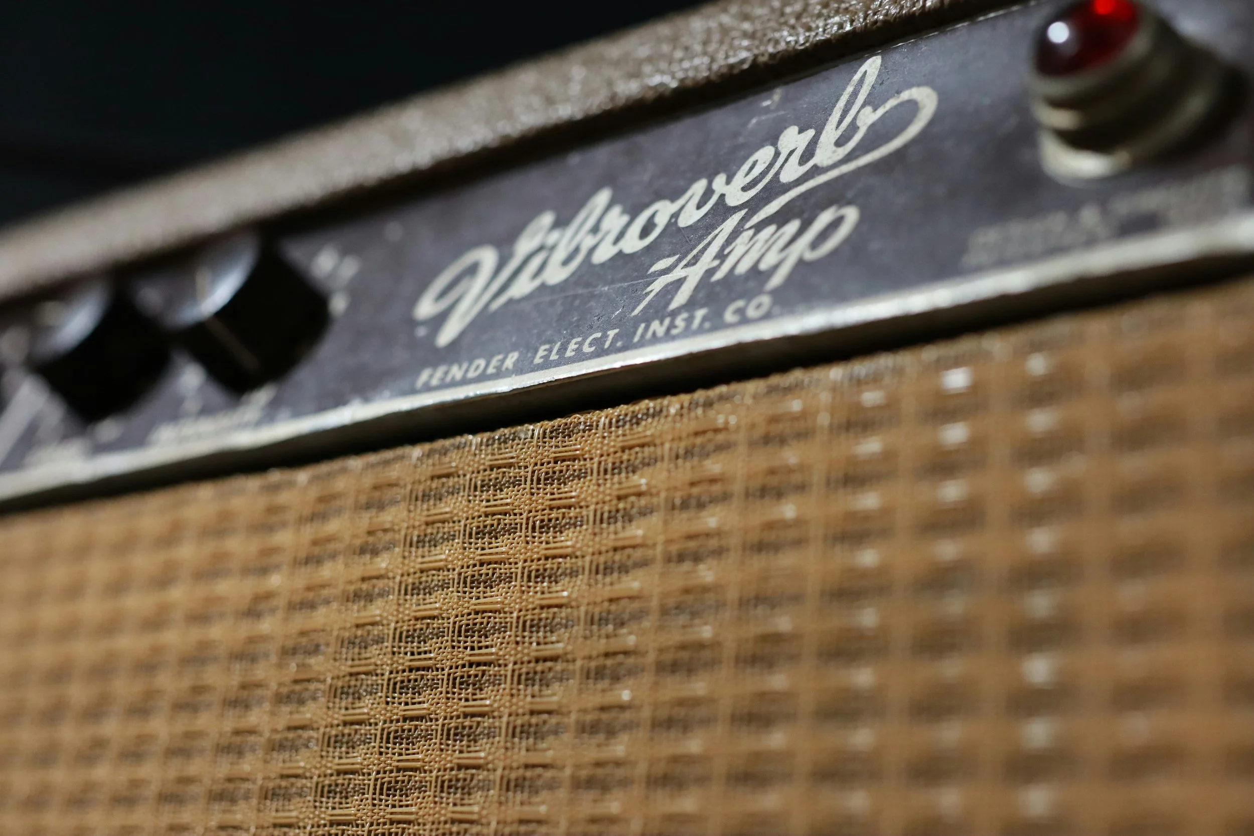 Close-up of a vintage Vibroworld Amp with a textured brown speaker grille and control knobs.