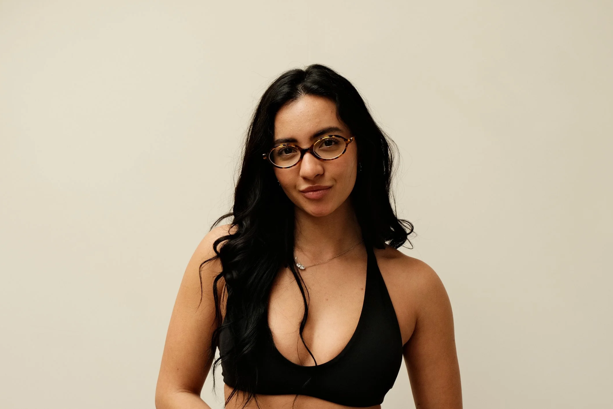 Person flipping through a large, off-white book on a wooden table, with various textured samples and small dishes nearby.