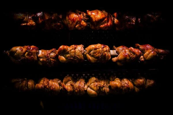 Chicken skewers cooking on a grill.