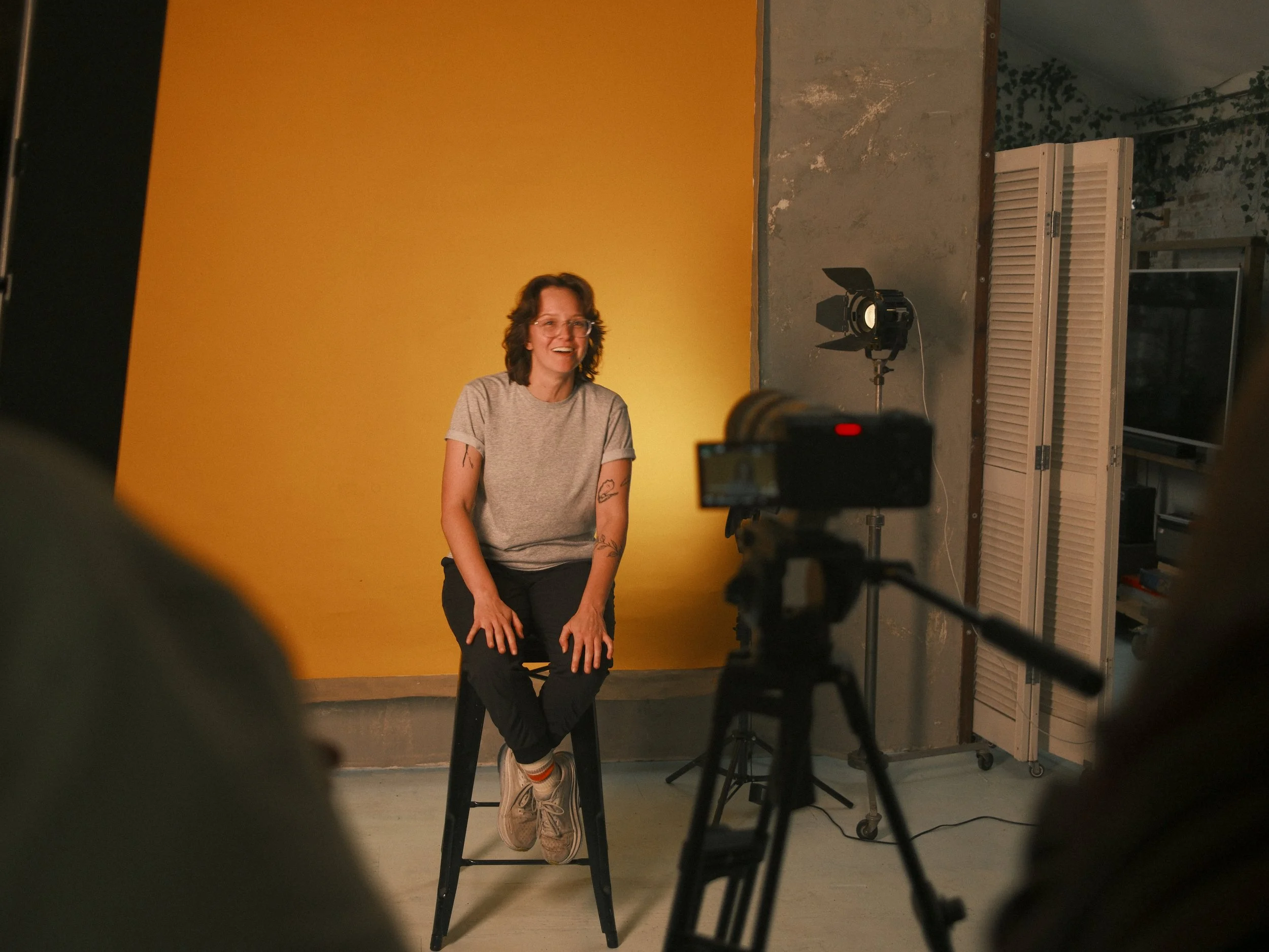 Woman in chair in front of yellow background