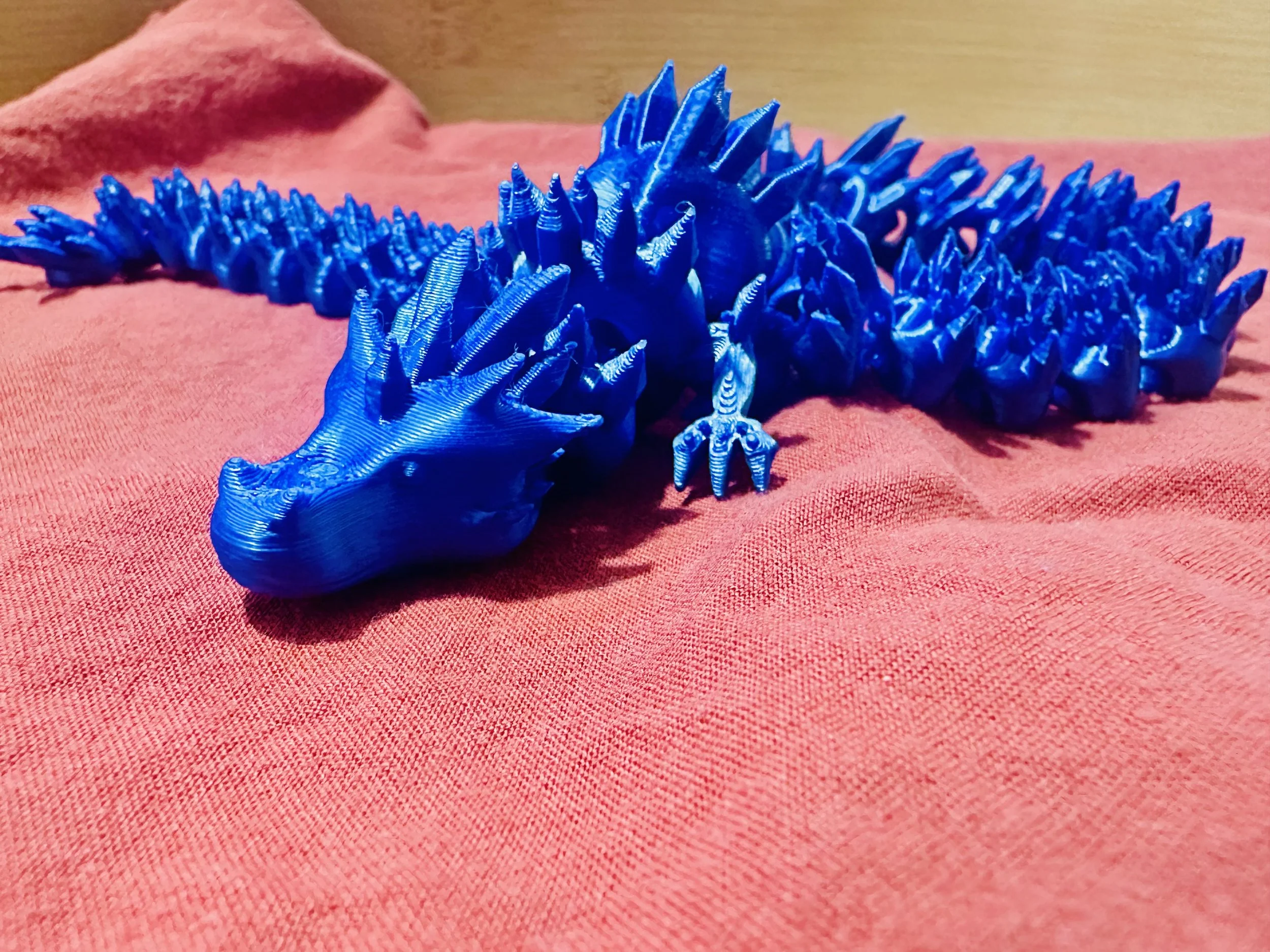 A blue, shiny dragon with a flexible body.