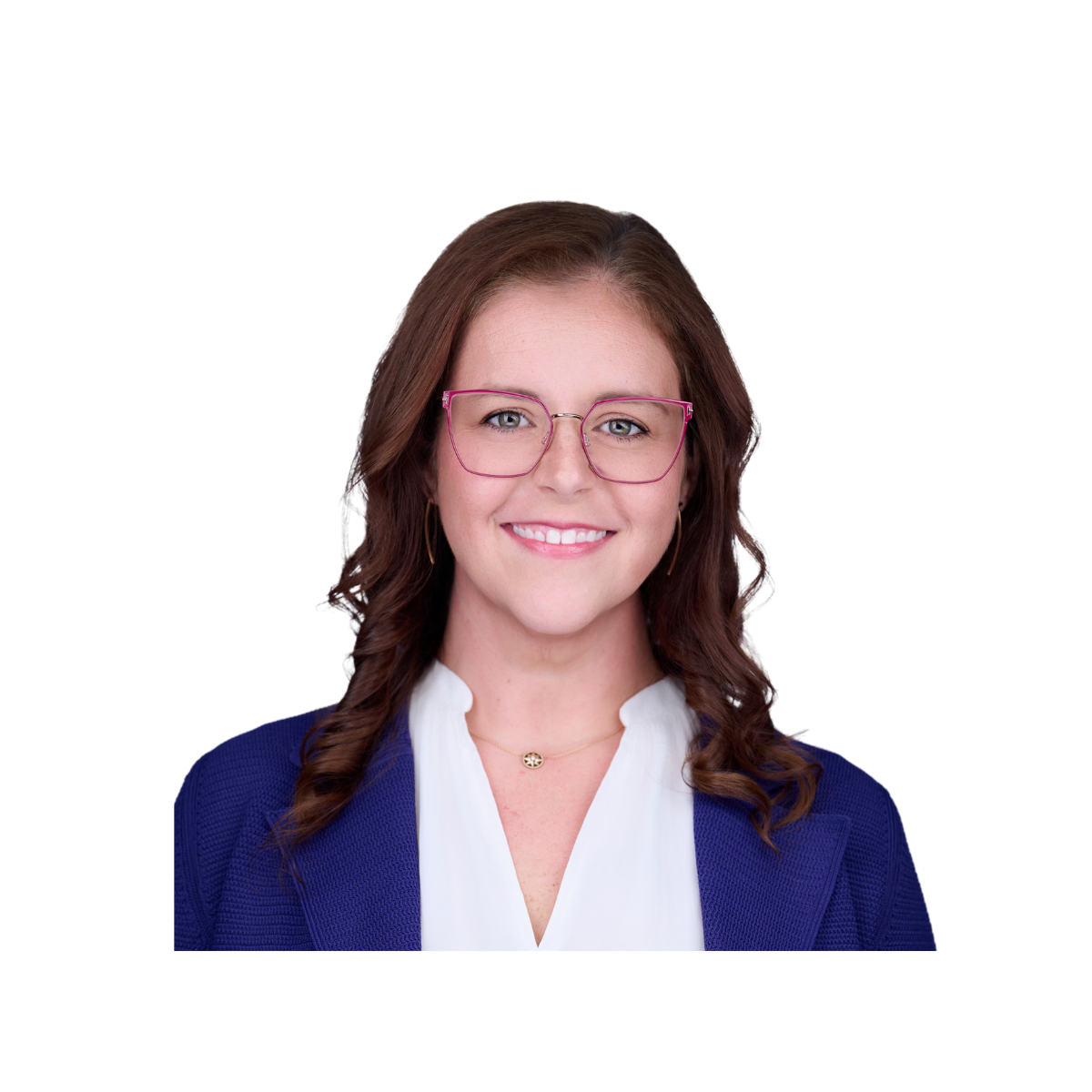 A woman with brown hair, wearing pink glasses, a white blouse, a blue blazer, and gold jewelry, smiling at the camera.