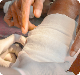 A person wrapping a bandage around another person's hand.
