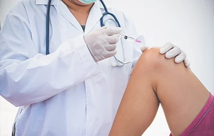 Medical professional administering a vaccine injection into a patient's arm.