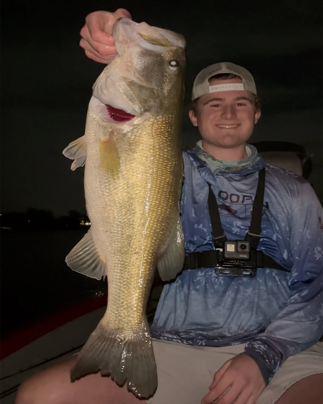 Charlie Murphy holding a large fish at night