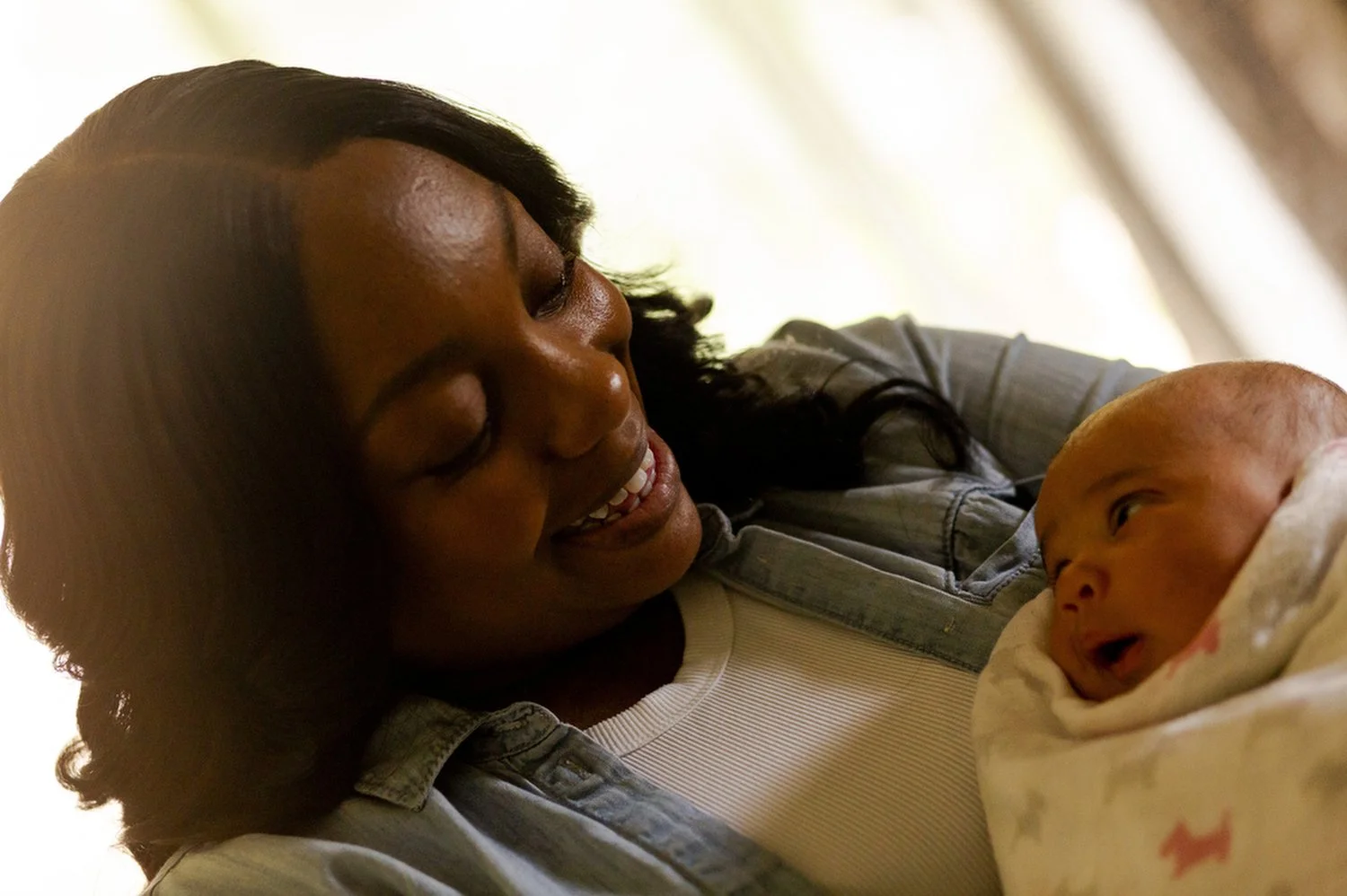 Bree Stallings, certified doula, at postpartum visit, Detroit, MI pictured with a baby she helped deliver